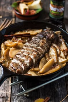 a skillet with some meat and potatoes in it