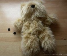 a teddy bear is laying on the floor next to some black beads