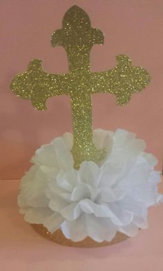 a cake topper with a cross on it and white ruffle around the base