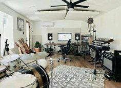 a living room filled with furniture and lots of musical equipment on top of a hard wood floor