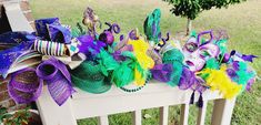 a white bench topped with lots of mardi gras masks and decorations on top of it