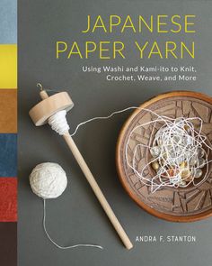 a book with yarn and knitting needles on the cover, next to a ball of thread