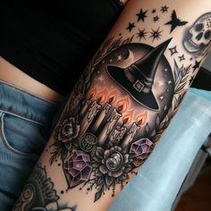 a woman with a tattoo on her arm wearing a witches hat and holding a candle