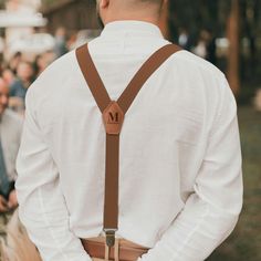 a man wearing suspenders and a white shirt is standing in front of an audience