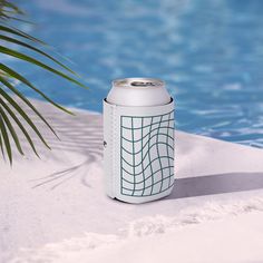 a can of soda sitting next to a swimming pool