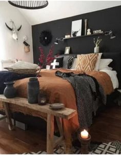 a bed room with a neatly made bed next to a wooden table and two candles