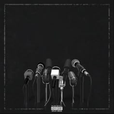 a bunch of microphones are lined up in front of each other on a black background