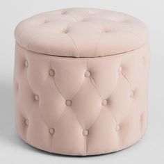 a round pink ottoman with buttons on it