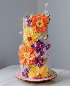 a multi - tiered cake decorated with flowers on a plate