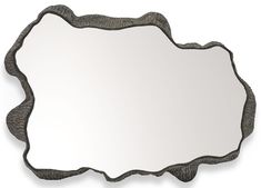 a mirror that is sitting on top of a white wall with an ornate frame around it