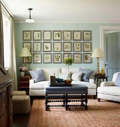 a living room filled with furniture and pictures on the wall above it's coffee table