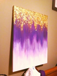 a painting is hanging on the wall next to a purple and white bedding set