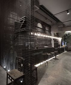 the interior of a restaurant with black walls and wooden chairs on the floor next to it