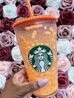 a hand holding up a starbucks cup with glitter on it