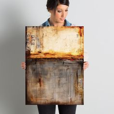 a woman holding up a piece of art that looks like it has been painted on