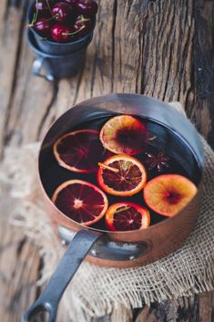 a pan filled with blood oranges on top of a wooden table