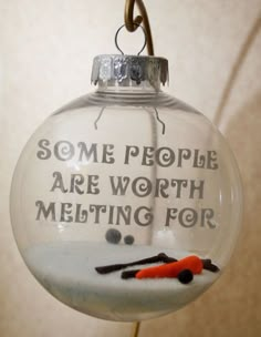 a glass ornament with some writing on it and scissors hanging from the top