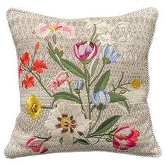 an embroidered pillow with colorful flowers on the front and back, sitting on a white background