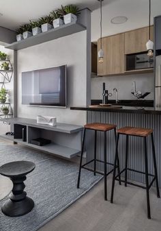 a living room filled with furniture and a flat screen tv mounted on a wall above a bar