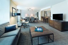 a living room filled with furniture and a flat screen tv on top of a wooden table