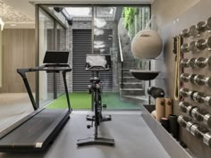 there is a gym with treadmills and exercise equipment in the room that has glass doors