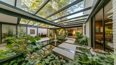 the inside of a house with lots of plants and water in it's center