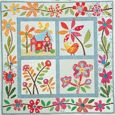 a quilted wall hanging with flowers and birds on it's sides, in the middle