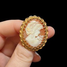 "Mid-century 14K gold cameo brooch. Circa 1960's. Genuine shell cameo set in a heavy 14K gold setting. 1.25\" inches long, 1.1\" inches wide. Marked on the pin stem. Depicts a beautiful young woman wearing long earrings and a dress with a large bow on her shoulder. The brooch is in excellent condition. Could be converted to a pendant. A rare find.  A stunning gift for that special someone. Pleasee contact me if you have any questions." Vintage Yellow Gold Oval Brooch, Vintage Cameo Brooch In Yellow Gold, Vintage Yellow Gold Cameo Brooch, Cameo Jewelry, Cameo Brooch, Large Bow, Long Earrings, Young Woman, Beautiful Earrings