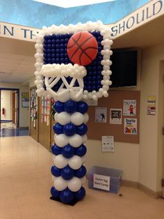 an inflatable basketball and hoop on display at the entrance of a school hallway