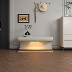 a white bench with a light under it in a room next to a wall mounted clock