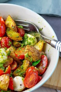 a white bowl filled with lots of different types of veggies on top of a wooden cutting board