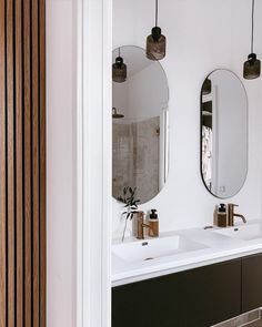 a bathroom with two sinks and mirrors on the wall