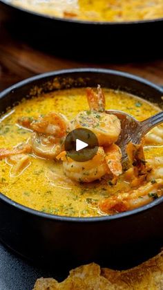 a bowl of soup with shrimp and cheese in it