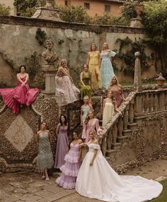 a group of women standing next to each other on top of a stone staircase in front of a building