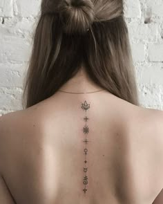 the back of a woman's neck with tattoos on it