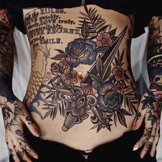 a woman with tattoos on her stomach and hands in front of her back, showing the lower part of her body