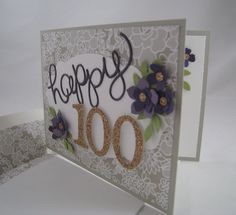 a happy birthday card with purple flowers and the number 100 on it's side