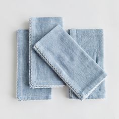 three blue linen napkins with scalloped edges