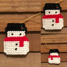 two small ornaments are hanging on a wooden wall, one has a snowman and the other has a red scarf