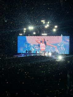 the stage is lit up with lights and confetti as she performs on it