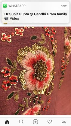 the back of a dress with red flowers on it, and gold trimmings