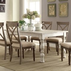 a dining room table with six chairs and a vase on top of it in front of a window