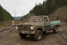 an old pick up truck sitting in the mud