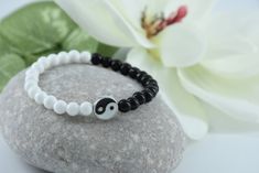 "Keep your life in balance!  Ying and Yang, opposite but interconnecting. Ancient Chinese philosophy thought these symbols to represent vital energy and the harmony of being in balance. Metal Charm *  Yin Yang bead in black and white with small stones that accent each side *  bead measures approximately 3/8\". Bracelet Cord * stretch elastic cord doubled for strength * half white and half black beaded bracelet to accent to the yin yang bead * full length of bracelet is approximately 8 inches   * if you require a longer length please note in comments when ordering Please see my shop policies and shipping for additional information." Yin Yang Bracelet, Chinese Philosophy, Yin Yang Symbol, Bracelet Cord, Cord Bracelet, Ying Yang, Cord Bracelets, Ancient Chinese, Metal Charm