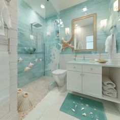 a bathroom with blue and white tiles on the walls, along with seashells