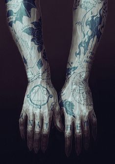 two hands with tattoos on them are shown