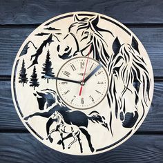 a wooden clock with horses and trees on it