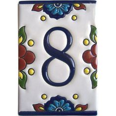 the number eight is painted in blue and red flowers on a white tile wall or floor