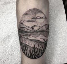 a black and white landscape tattoo on the leg