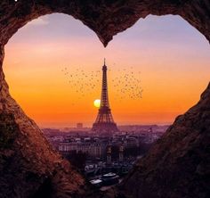 the eiffel tower is seen through a heart shaped hole